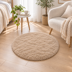Khaki round plush area rug styled beside a bed and reading chair.