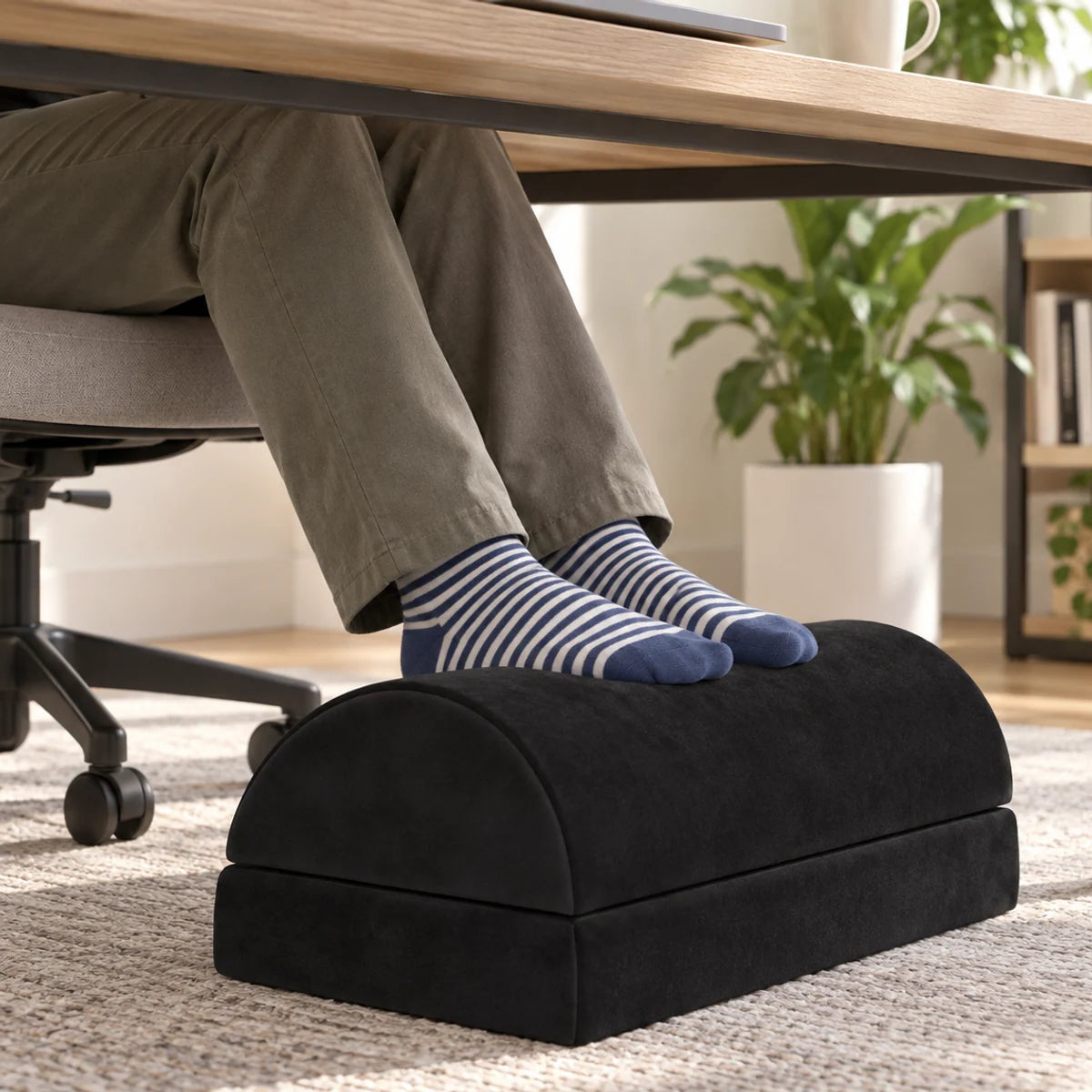 Black two-piece footrest used beneath a home office desk