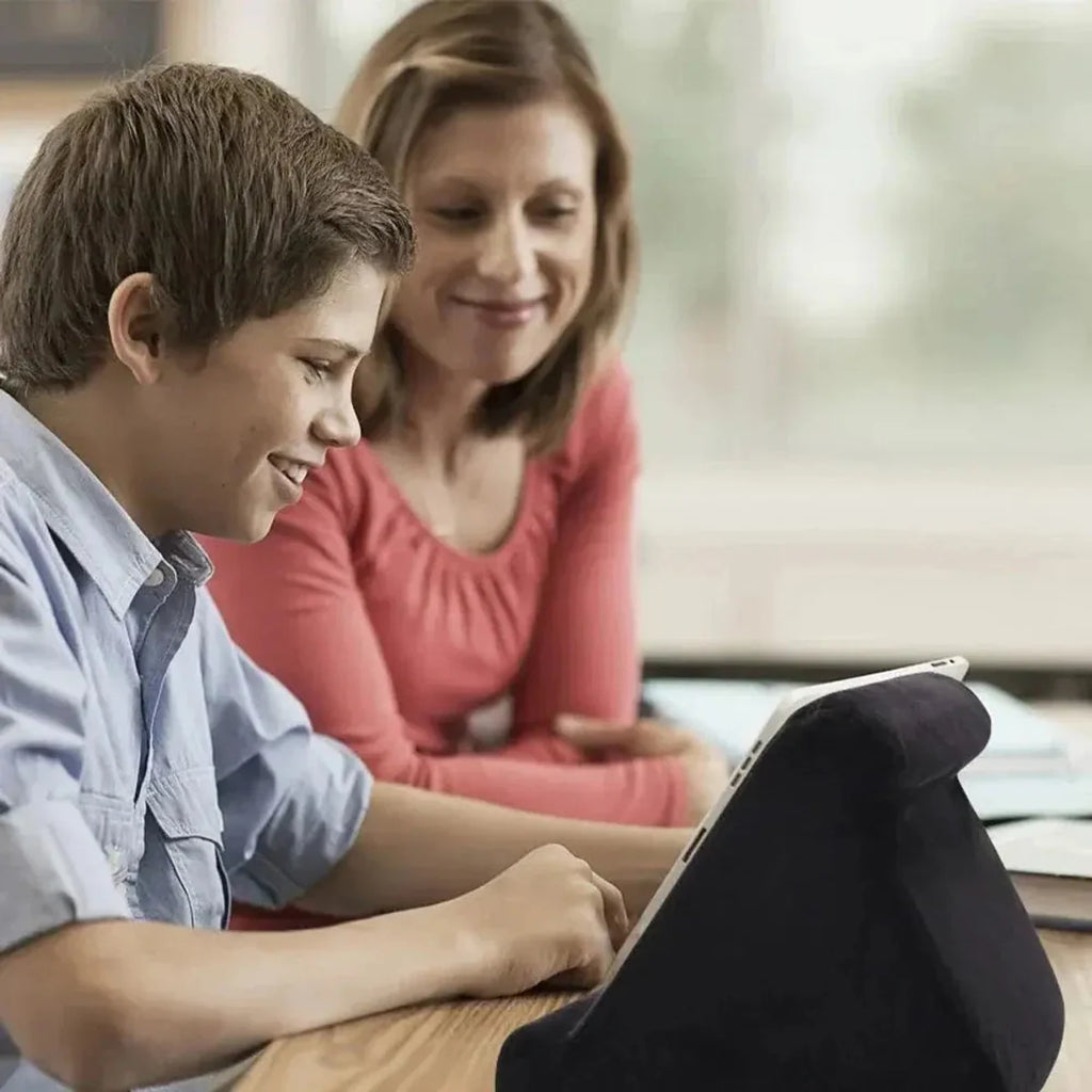 Black tablet cushion stand used for hands-free viewing at a table