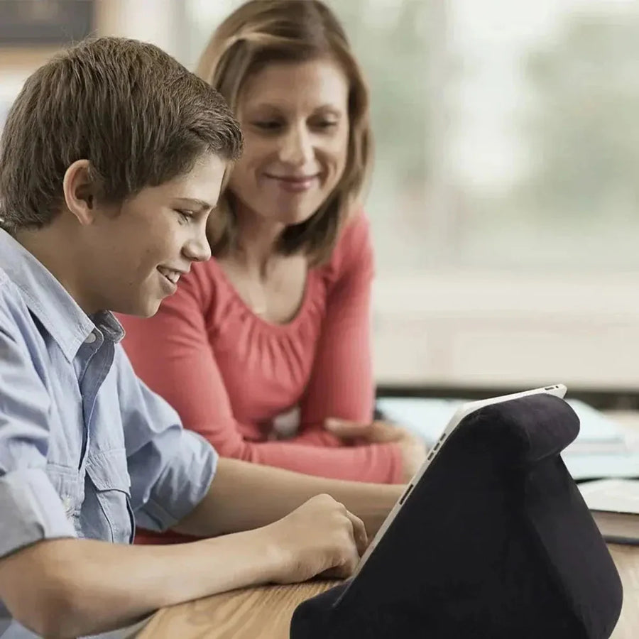 Black tablet cushion stand used for hands-free viewing at a table