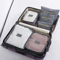 Grey six-piece packing cube set arranged inside an open suitcase