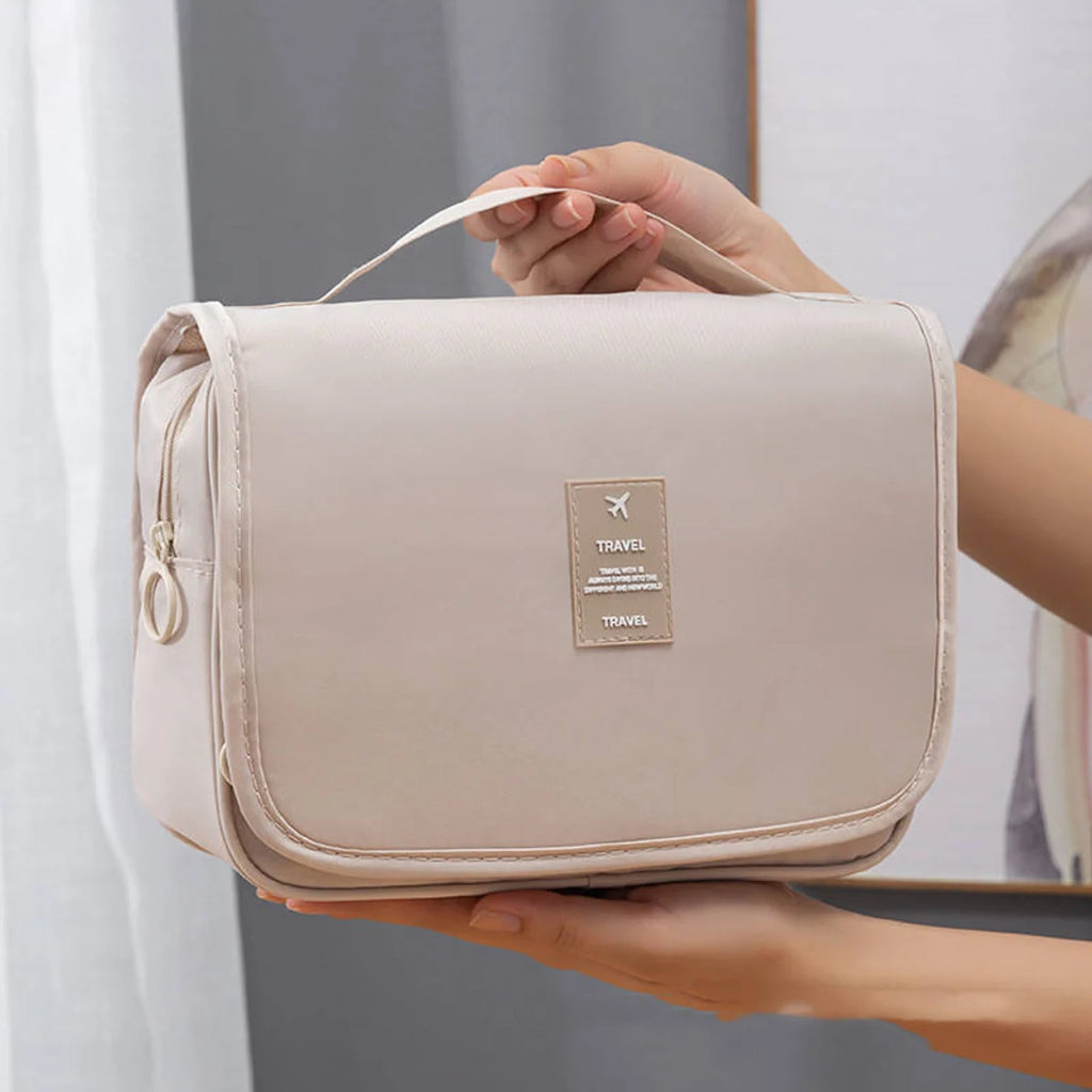 Closed beige hanging toiletry bag with carry handle