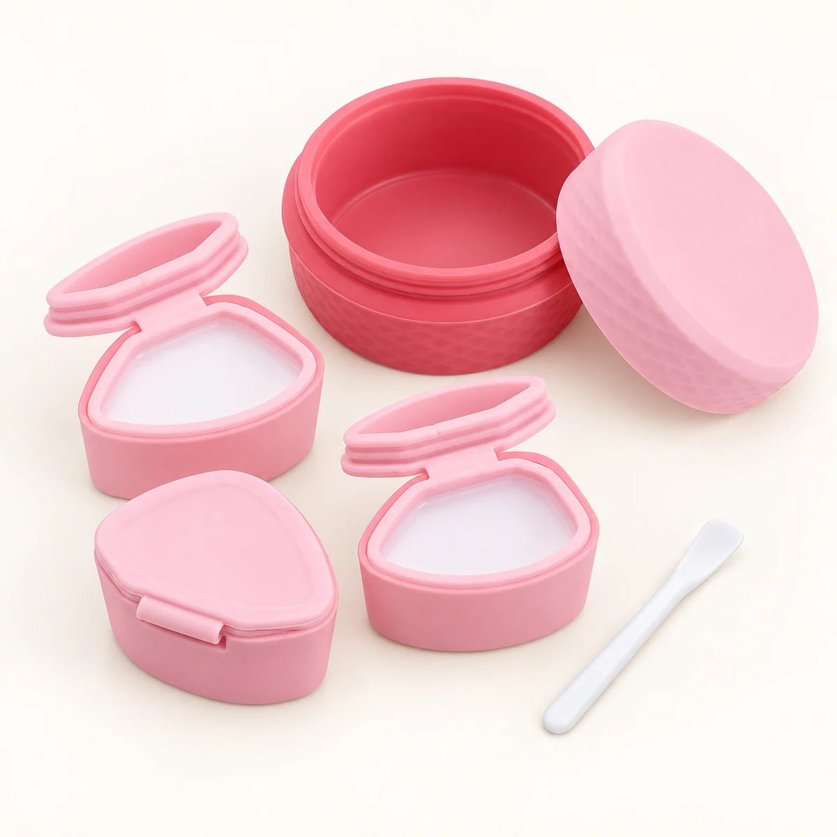 Pink cosmetic storage organizer with three removable dispensers and spoon