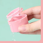 Pink cosmetic dispenser being rinsed under running water