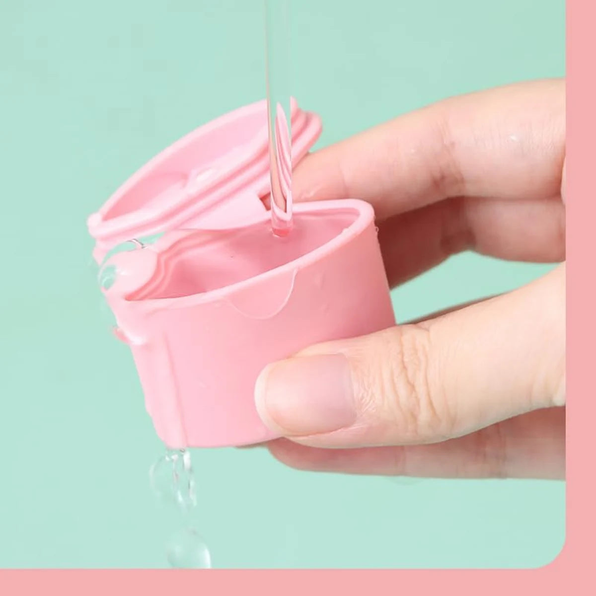 Pink cosmetic dispenser being rinsed under running water