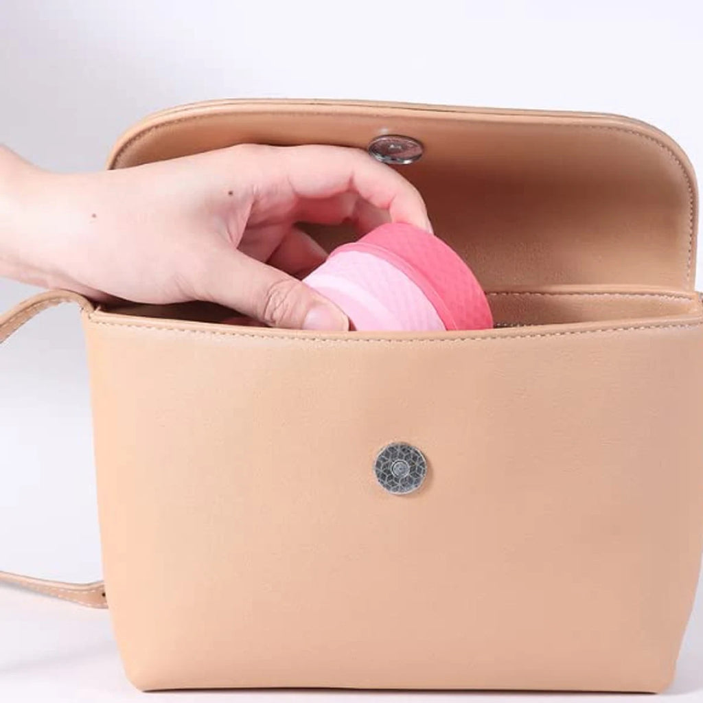 Pink cosmetic storage organizer being placed inside a travel bag