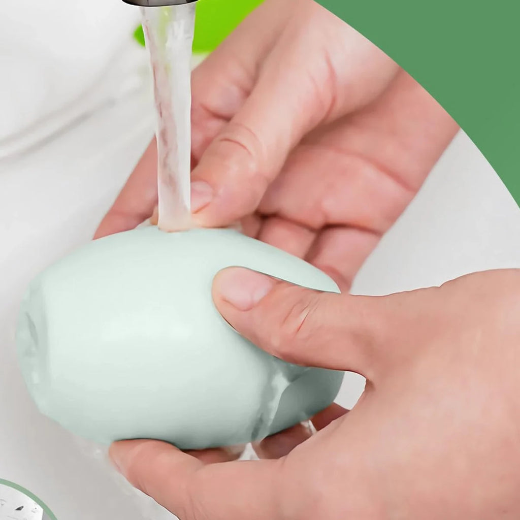 Green reusable lint roller being rinsed under a faucet