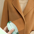 Green reusable lint roller removing lint from a coat