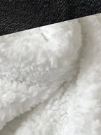 Close view of black plush fabric and white sherpa lining