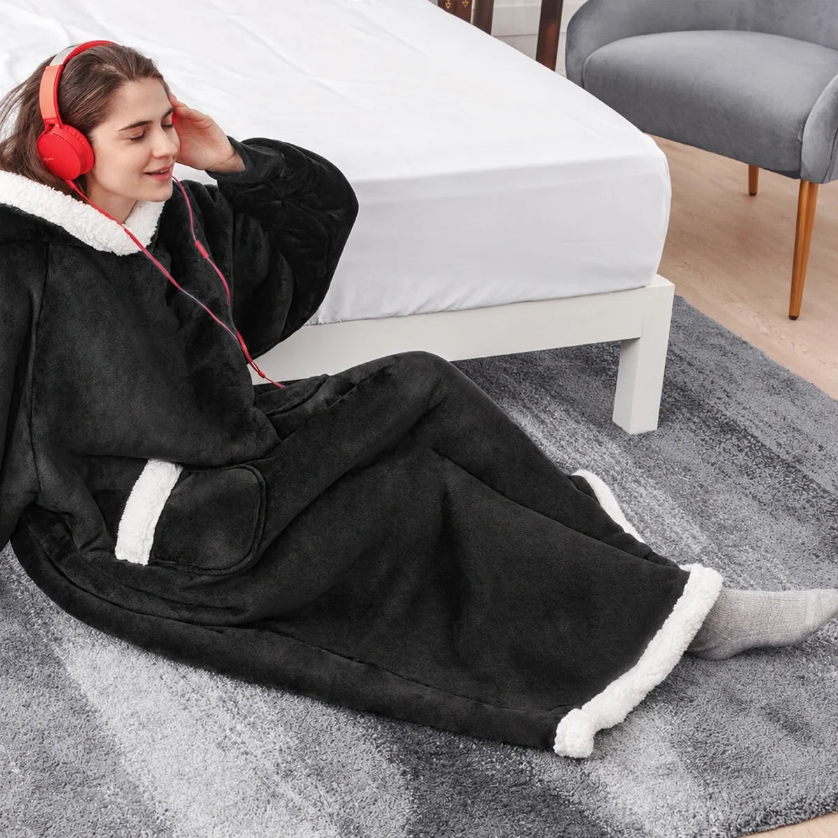Black oversized wearable blanket hoodie worn in a bedroom