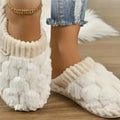 White plush indoor slippers worn on a wood floor