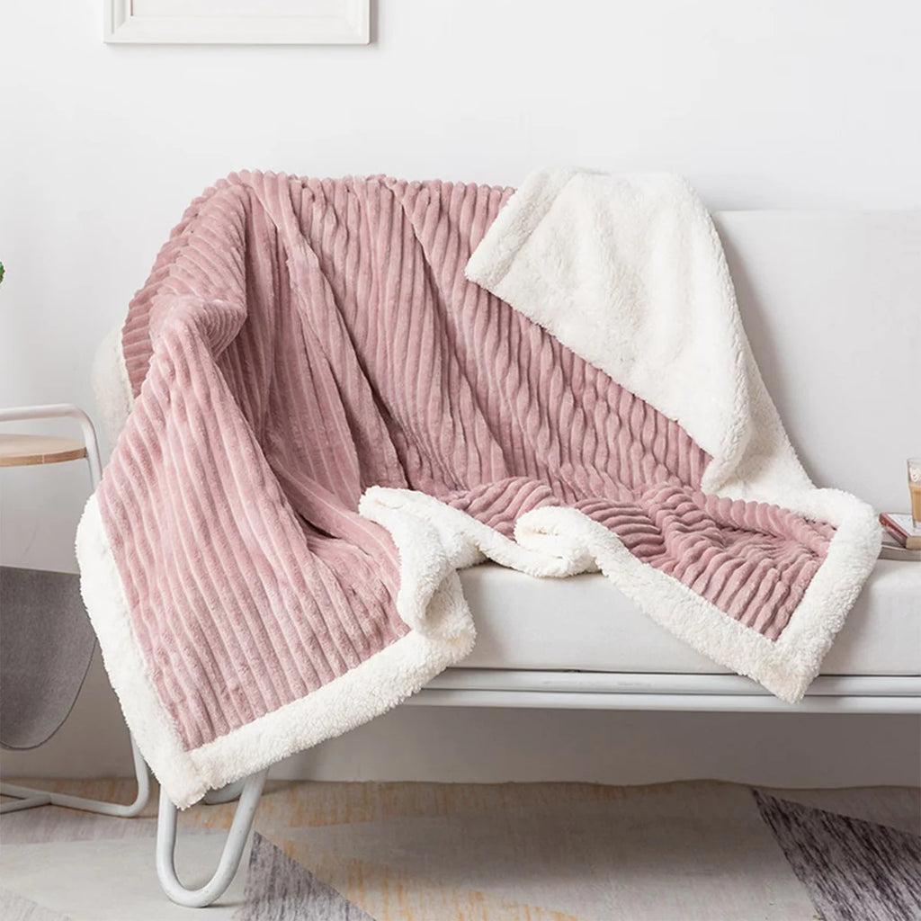 Pink ribbed throw blanket draped over a white chair