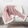 Pink ribbed throw blanket draped over a white chair