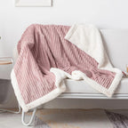 Pink ribbed throw blanket draped over a white chair