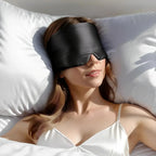 Black soft sleep mask worn while resting in bed