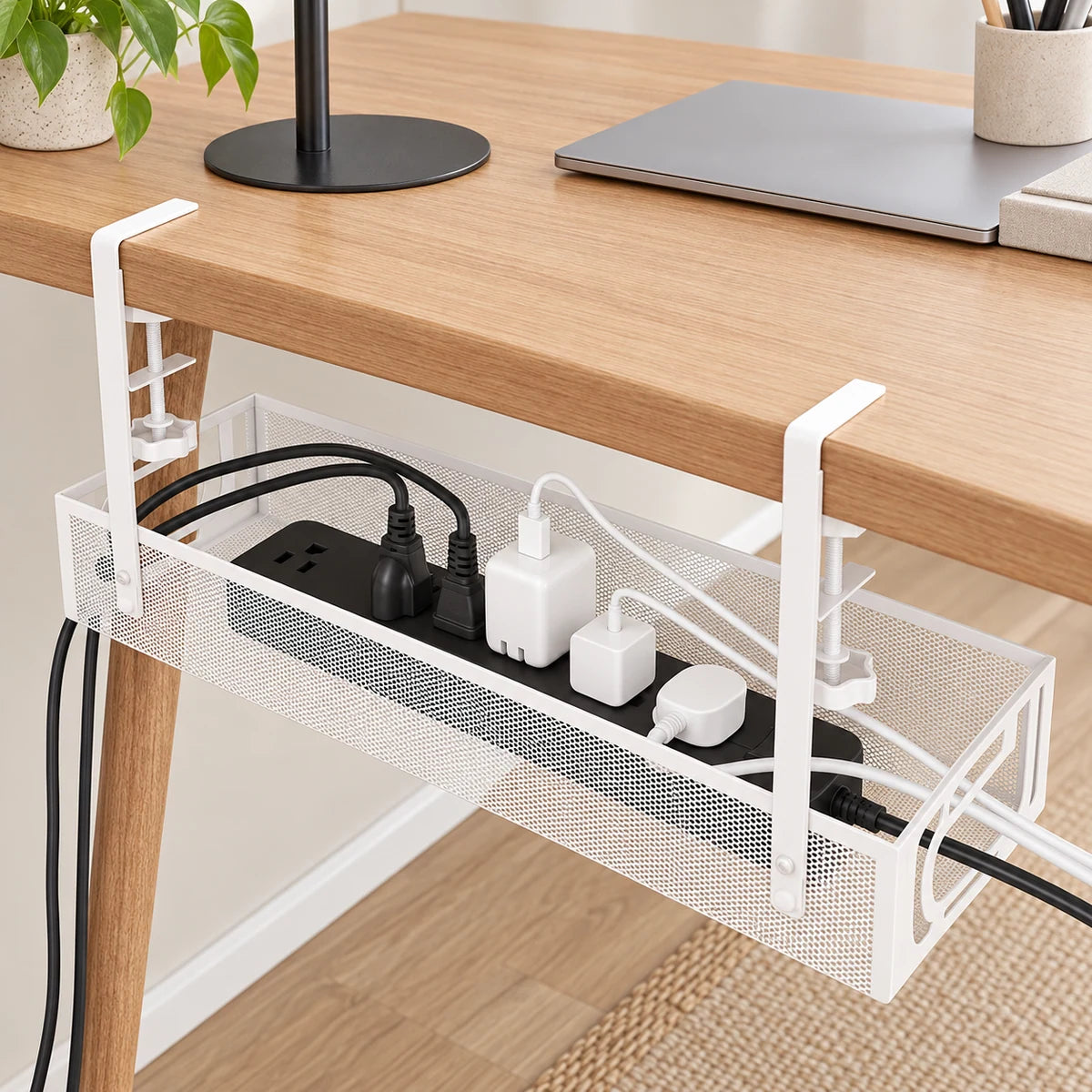 White under-desk cable tray organizing a power strip, chargers and routed cables