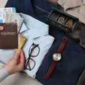 Black three-slot watch travel roll open inside packed luggage