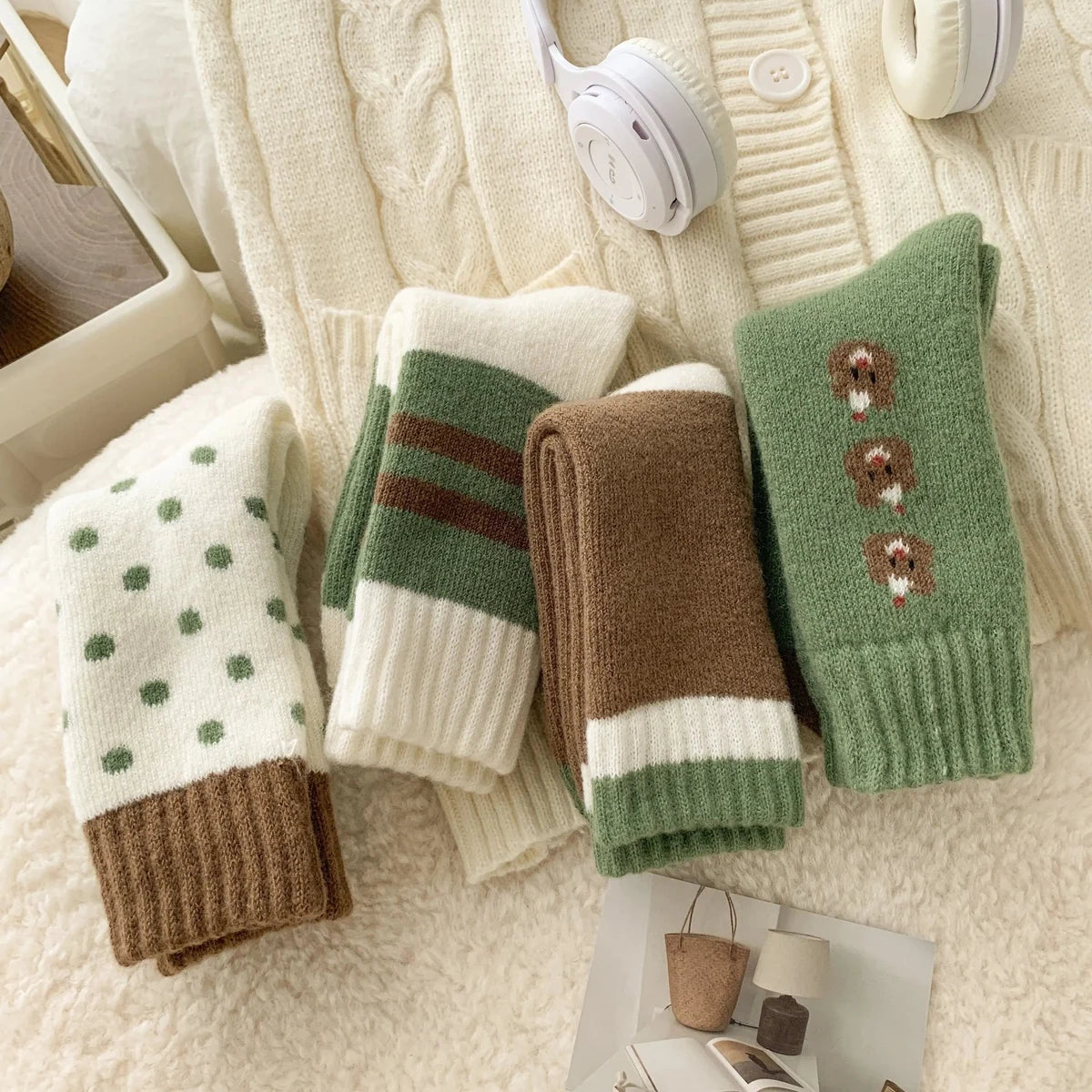 Four pairs of winter socks in green, cream and brown patterns