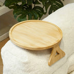 Round wooden sofa arm tray on a light couch