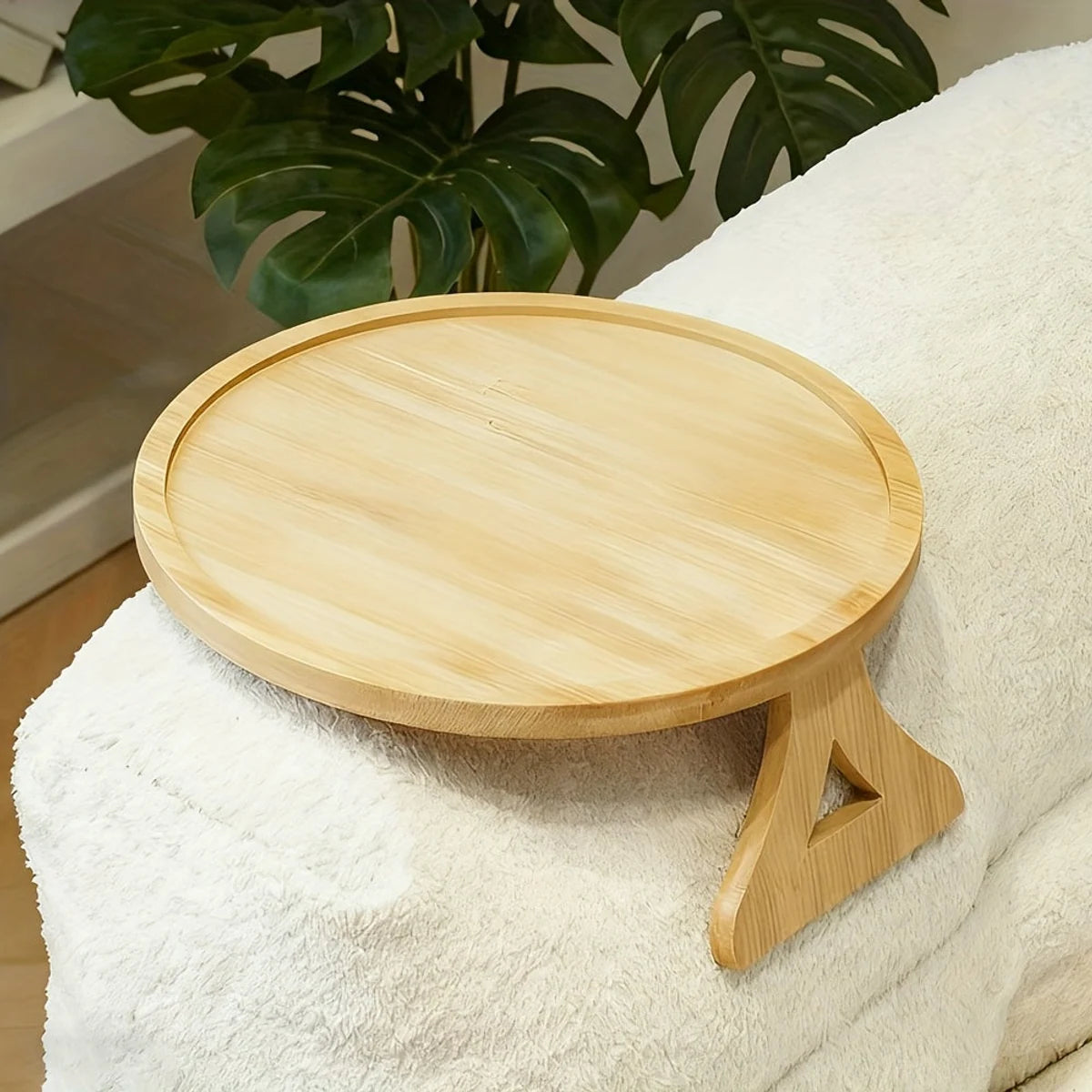 Round wooden sofa arm tray on a light couch